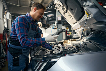 Male checking voltmeter readings in the vehicle service center