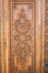 traditional oriental Arabic Uzbek Islamic patterns arabesque ornament on an wooden carved door in Uzbekistan close-up