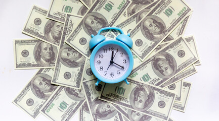 Time - money concept with clock and dollar bills closeup