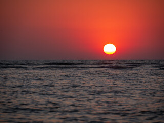 Beautiful sunset with sun close to Arabian Sea horizon .