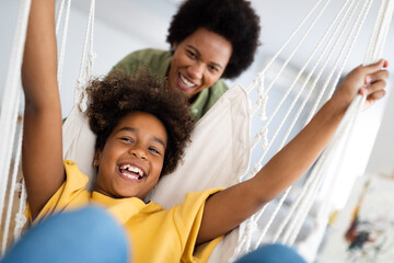Playful young African American girl having fun with mom at home.