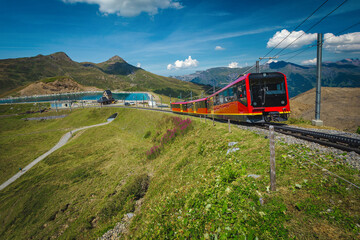 Red tourist train and mountain lake in background, Grindelwald, Switzerland