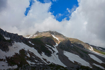Majestic Mountain Peak Piercing Through Clouds