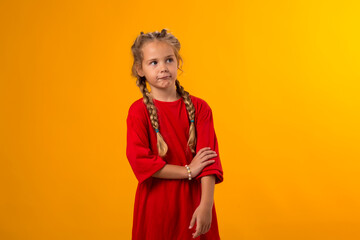 Kid girl looking at camera over yellow background. Childhood and  positive emotions concept