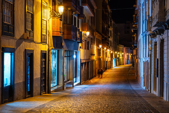 Picturesque streets with white colonial-style buildings at night lit up with street lamps, Santa Cruz, La Palma, - Powered by Adobe