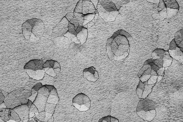 Close-up of irregularly distributed impact marks on a plastered wall.