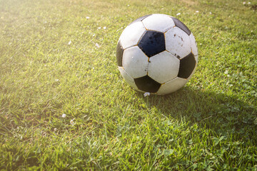Obraz premium Ball of football game in grass , sun glare from corner
