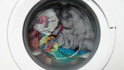 Many washable clothes in the drum of a home washing machine