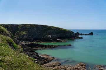 La côte sauvage de la presqu'île de Crozon, baignée par un ciel bleu et les eaux turquoises de la mer d'Iroise.