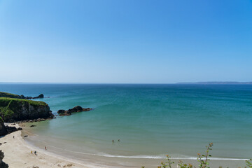 Vue panoramique sur une plage de sable et les eaux turquoise de la mer d'Iroise en été, sous un magnifique ciel bleu, sur la presqu'île de Crozon en Bretagne.