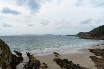 Plage et sillons rocheux sous un ciel couvert sur la presqu'île de Crozon en Bretagne.