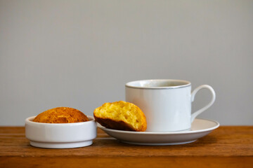 Afternoon coffee served in a white cup with cornbread or cheese bread