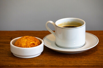 Afternoon coffee served in a white cup with cornbread or cheese bread