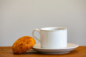 Afternoon coffee served in a white cup with cornbread or cheese bread