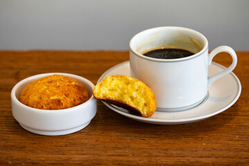 Afternoon coffee served in a white cup with cornbread or cheese bread