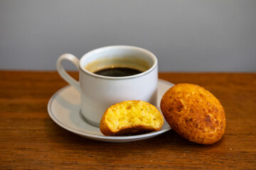 Afternoon coffee served in a white cup with cornbread or cheese bread