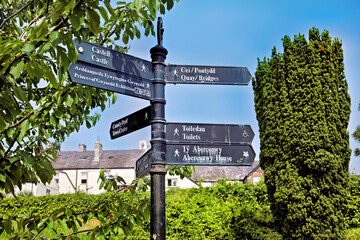 Multilingual signpost with landmark directions in quaint town of Conway Wales, surrounded by...