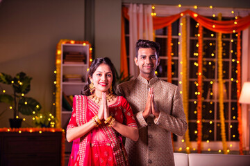 Indian young couple celebrating diwali at home posing for photograph