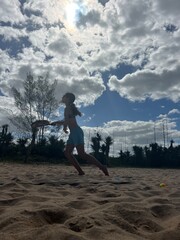 girl playing beach tennis on the beach