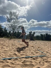 girl playing beach tennis on the beach