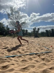 girl playing beach tennis on the beach