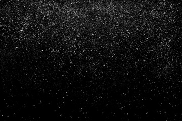 Freeze motion of white powder coming down, isolated on black, dark background. Abstract design of falling dust cloud. Particles cloud screen saver, wallpaper with copy space. Rain, snow fall concept