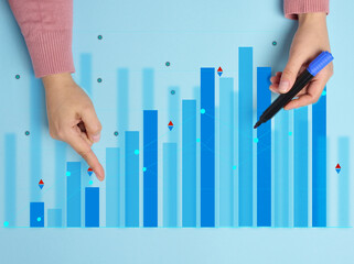 Graph with growing indicators and a female hand with a marker on a blue background