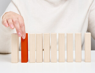 Wooden blocks on the table, a woman's hand holds one. The concept of finding unique