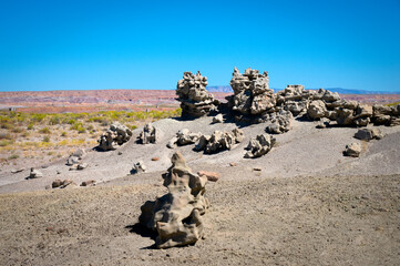 Weird rock formations at Fantasy Canyon with red rocks in the background.