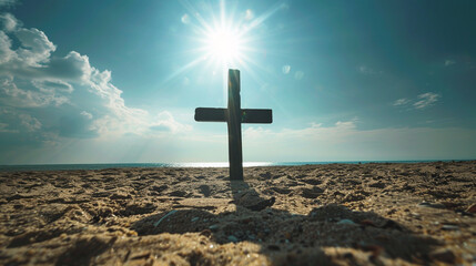 A Christian cross on a sandy beach at noon, with the sun directly overhead and the bright sky creating a stark contrast with the dark shadow of the cross on the sand.
