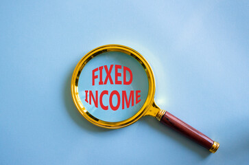 Fixed Income symbol. Concept word Fixed Income on magnifying glass. Beautiful blue background....