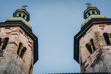 Two old small catholic church towers with crosses on green domes in Krakow, Poland