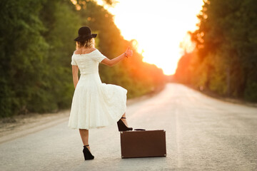 girl with a suitcase hitchhiking