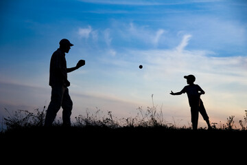 A Happy child with parent playing baseball concept in park in nature