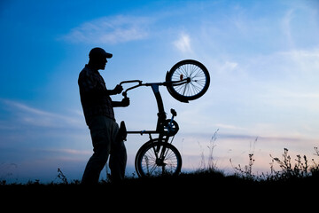 A Happy guy on a bike concept in the park on nature travel silhouette