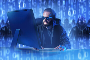 Man hacker in hood. Cyber security specialist. Hacker works while sitting at computer. Binary code...