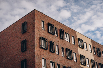 Corner of modern brick house, building facade with windows and geometric frame decor