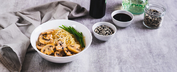 Funchose rice noodles with mushrooms and green onions in a bowl on the table web banner