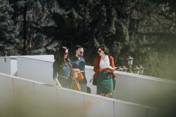 Three business professionals engaged in a discussion while walking outdoors, with a document in...
