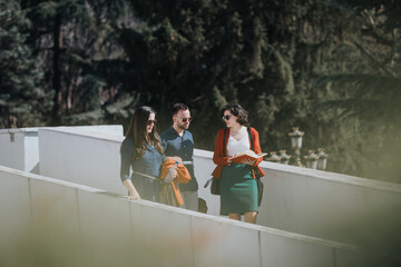 Three business professionals engaged in a discussion while walking outdoors, with a document in hand and casual expressions.