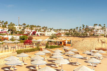 Chairs under umbrellas on tropical beach. Summer vacation concept.