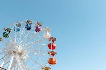 Old colorful ferris wheel on background of blue sky.