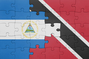puzzle with the colourful national flag of trinidad and tobago and flag of nicaragua .