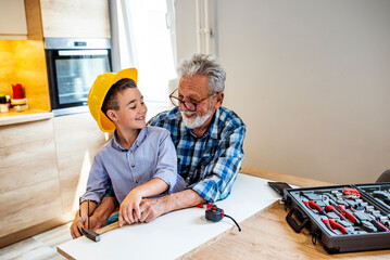 Learning craft with grandpa. Grandpa's little helper. Grandfather teaching his grandson. Boy and...