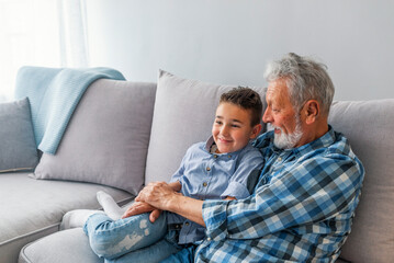Shot of a happy senior man smiling looking away his grandson hugging him, copyspace, relax family...