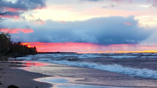 Pink and blue colors of sunset over the waves of Lake Superior in Michigan