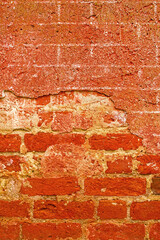 Red run down brick wall in closeup