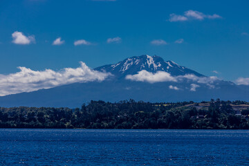 Osorno volcano mountain summit in Chile, Patagonia Andes. The ring of fire volcanic landscape with crater and lava active volcano in South America. Red rock frozen lava and snow on volcano top