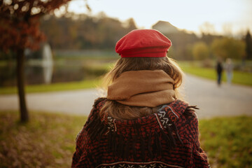 Seen from behind woman in red hat with scarf walking