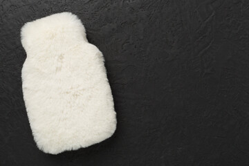 Fluffy water warmer bag on concrete background, top view
